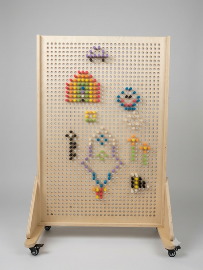 Free-standing JSTEM 120 birch plywood pegboard on castors with rainbow and flower peg designs