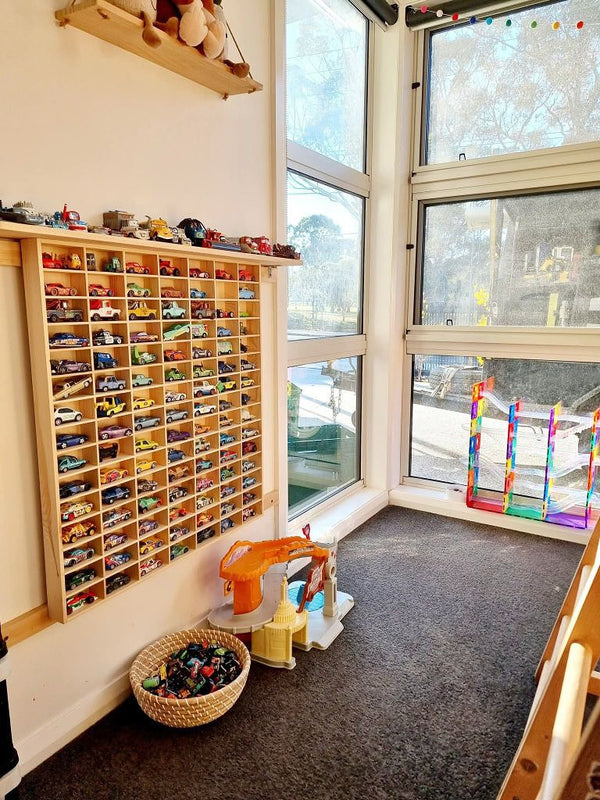 JCAR 105 mounted on a playroom wall beside the window, cars in every slot