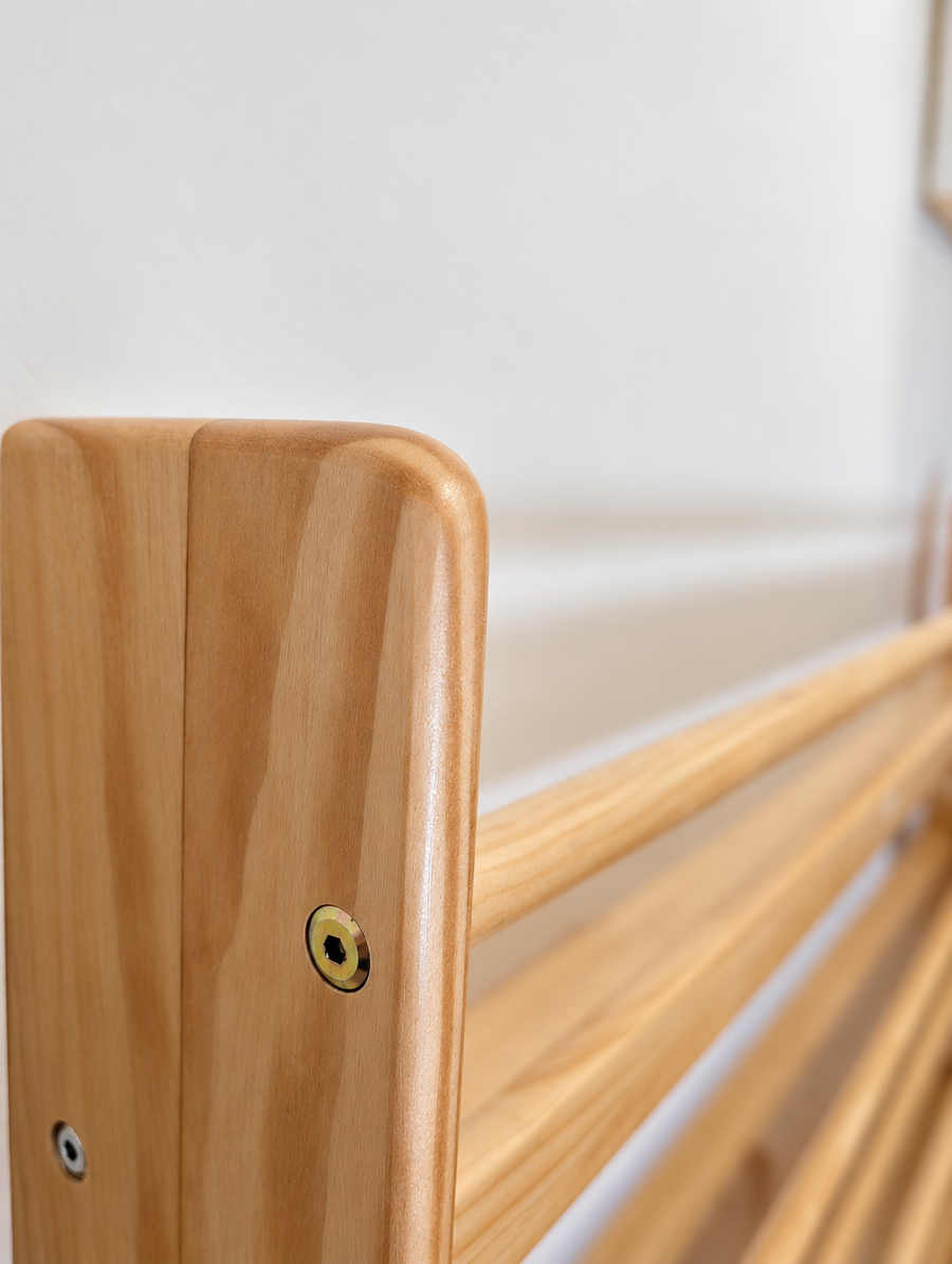 A rounded corner on a JoyKids pine shelf, the fixing screw sunk flush into the timber