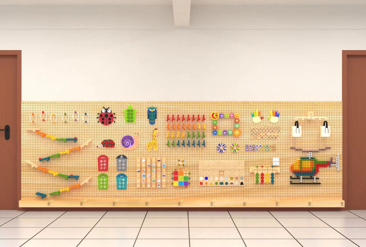 A run of WonderWall pegboards spanning a wall between two doors, filled with marble runs, threading shapes, number lines, pattern tiles and a helicopter built from pegs